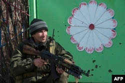 A pro-Russian rebel stands guard on a street in the frontline town of Shyrokyne.