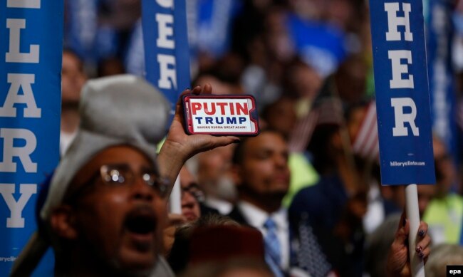 Съезд Демократической партии США в июле 2016 года. На телефоне надпись: "Путин – Тамп делают Россию вновь великой"