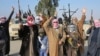 Tribal fighters gesture after deploying themselves on the streets of Ramadi on January 6.