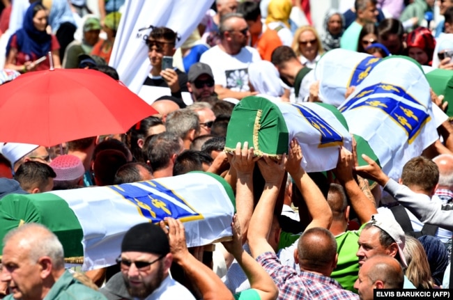 Disa persona bartin 33 trupat e identifikuar të Masakrës së Srebrenicës. Ata u varrosën në kompkeskin memorial në Potoçari. Bosnjë, 11 korrik, 2019.