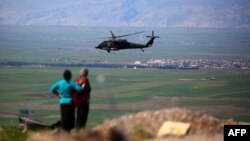 ABŞ koalisiyasının helikopteri Suriyada Derik kürd qəsəbəsinin yaxınlığında Türkiyə hava zərbələrinə məruz qalmış ərazi üzərində uçur