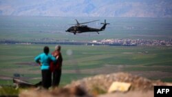 Медицинский вертолет возглавляемой США международной коалиции пролетает над городом Маликие, именуемый курдами Дерик, 25 апреля 2017 года.