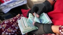 Ўзбекистоннинг 5000 сўмлик пулини санаб ўтирган аёл. Архив. 