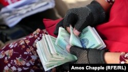 Ақша санап отырған өзбек әйелі. Көрнекі сурет.