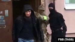 Russian FSB agents detain an unidentified suspect they said belonged to an Islamic State sleeper cell in Yaroslavl on May 4.