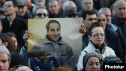 A protester holds a picture of Artur Sarkisian at a rally in Yerevan on March 17.