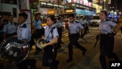 Rendőrök érkeznek feloszlatni egy kezdődő tüntetést Hongkongban, 2014. november 26-án