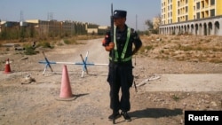 A Chinese police officer stands in position on a road near what is officially called a vocational education center in Xinjiang, China. Critics say such facilities are being used as mass internment camps. (file photo)