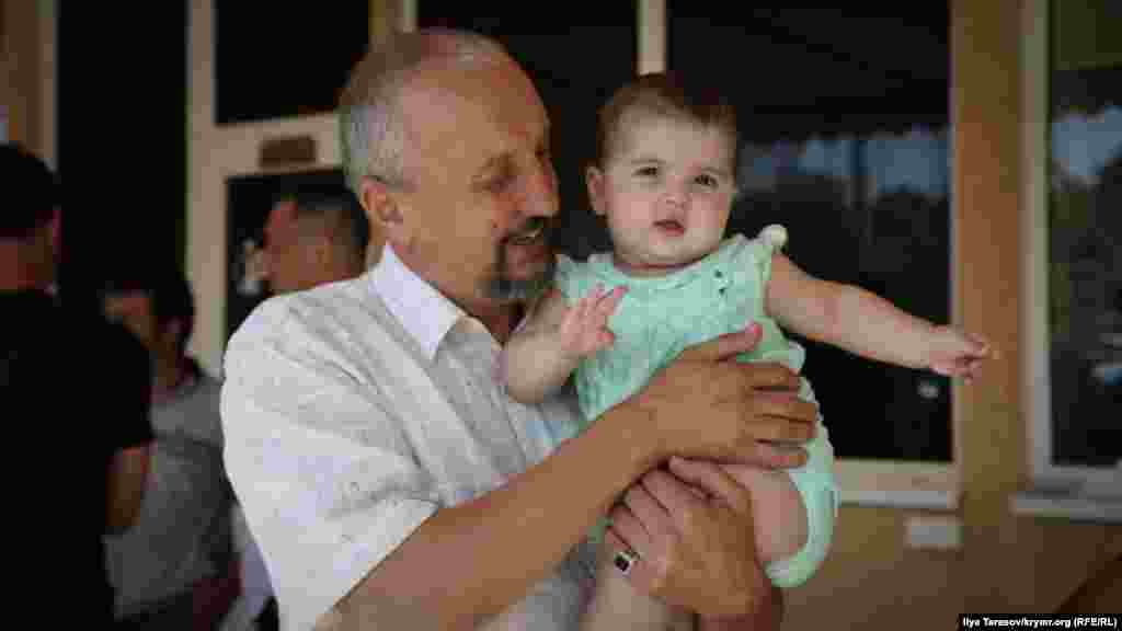 Рустем, отец Сервера Мустафаева, держит на руках Наджие, младшую дочь своего сына