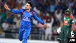 FILE: Rashid Khan (L) celebrates after taking a wicket in a Twenty20 cricket match.