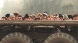 Bucharest residents look on as clashes between the Securitate and the army continue on December 24, 1989.