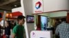 Iran -- People walk past the stand of French oil and gas company Total during Iran's annual International Oil, Gas, Refining & Petrochemical Exhibition in Tehran, May 06, 2015