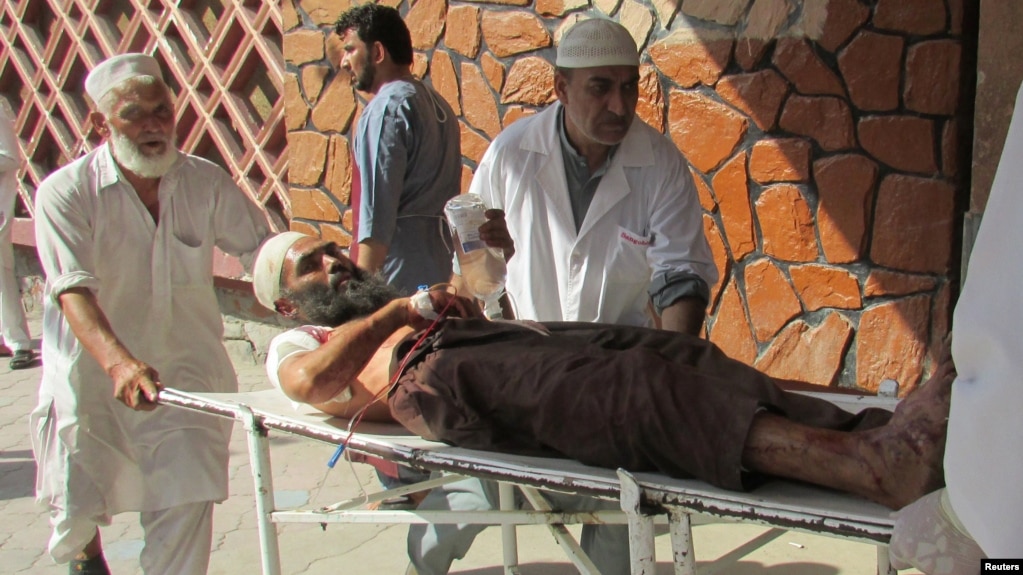 Afghan men carry an injured man to a hospital after a suicide attack in Nangarhar Province on September 11.