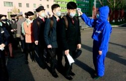 Проверка температуры у студентов и преподавателей Технологического университета Пхеньяна в день возобновления занятий после каникул. 22 апреля 2020 года