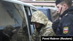 Захоплений український військовослужбовець виходить із мікроавтобуса біля будівлі суду в Сімферополі