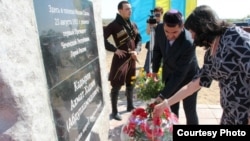 Возложение цветов у памятной стелы Ахмаду Кадырову в поселке Малая Сарань 23 августа 2012 года. В августе 2023 года на ней появились надписи "предатель"
