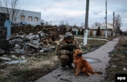 Український солдат грається з собакою на блокпосту біля Дебальцева. 24 грудня 2014 року