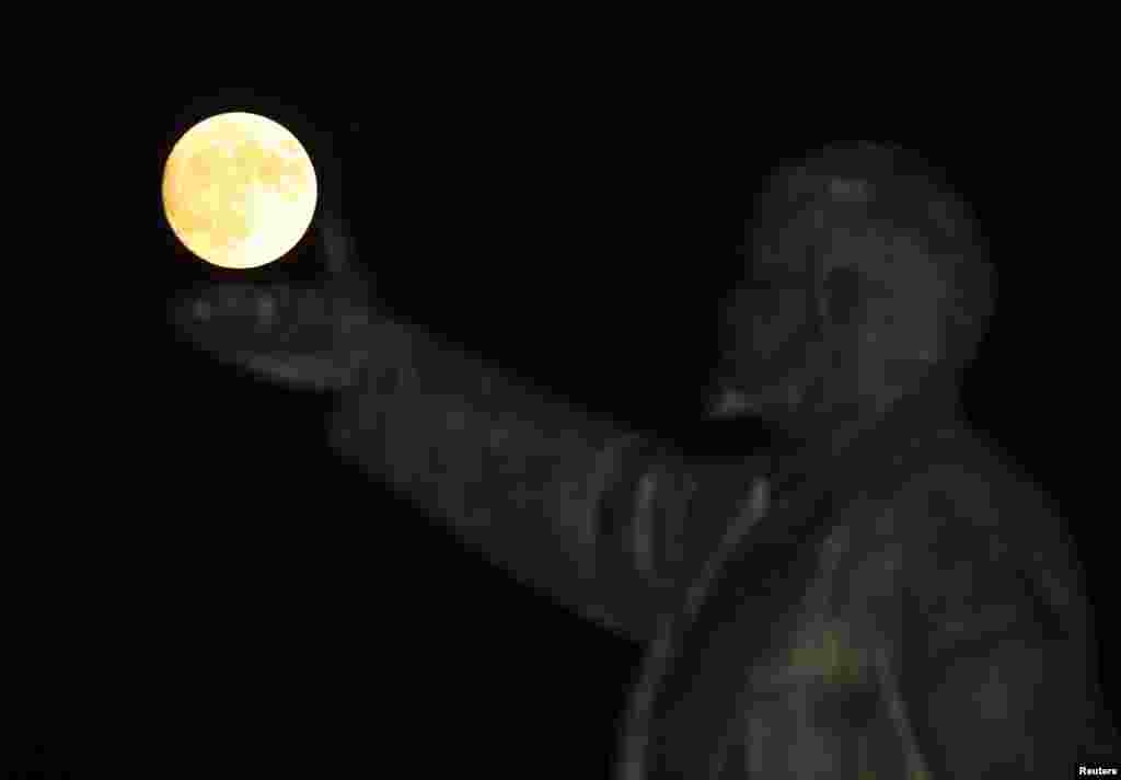 A so-called supermoon rises behind a statue of Soviet state founder Vladimir Lenin in Baikonur, Kazakhstan (Reuters/Shamil Zhumatov).&nbsp;