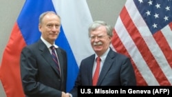 SWITZERLAND -- U.S. National Security Advisor John Bolton (righ) shakes hands with his Russian counterpart Nikolai Patrushev during a meeting at the US Mission in Geneva, August 23, 2018