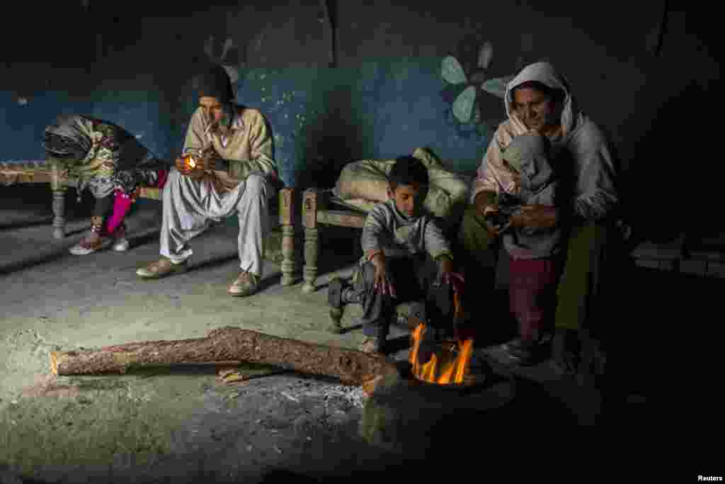 A Pakistani family sits around a wood fire at their house on Margalla Hills in Islamabad. (Reuters/Zohra Bensemra)