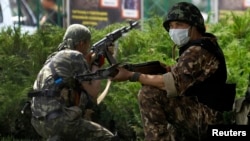 Pro-Russian fighters of the Vostok Battalion take up positions outside the local administration building in the eastern Ukrainian city of Donetsk on May 29.