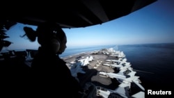 A U.S sailor keeps watch from the captain's bridge onboard the USS John C. Stennis as it makes its way to the Persian Gulf through the Strait of Hormuz on December 21.