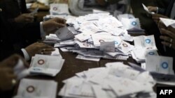 Egypt--Polling station officials deposit ballots during the second round of a referendum on a new draft constitution in Giza, south of Cairo, on December 22, 2012.