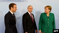 German Chancellor Angela Merkel (right) walks with French President Emmanuel Macron (left) and Russian President Vladimir Putin prior to a meeting during the G20 summit in Hamburg on July 8.