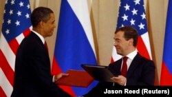 Президент США Барак Обама и президент России Дмитрий Медведев обмениваются документами о сокращении ядерных арсеналов двух стран 6 июля 2009 года