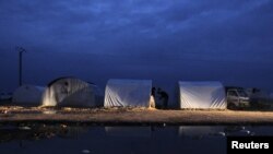 Tents housing Syrian refugees are reflected in pools of rainwater in the Bab al-Salam refugee camp in Azaz, near the Syrian-Turkish border.