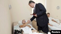 Petro Poroshenko cu un militar rănit de separatiști, intr-un spital din Kiev pe 21 iunie.