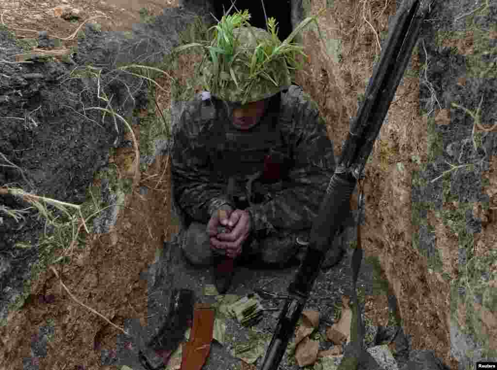 Український вояк перезаряджає зброю під час бою в Авдіївські промзоні. Авдіївка, 22 травня 2017 року