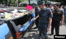 Валерій Осіпян розглядає сміттєві баки, якими демонстранти перегородили проспект, 28 червня 2015 року