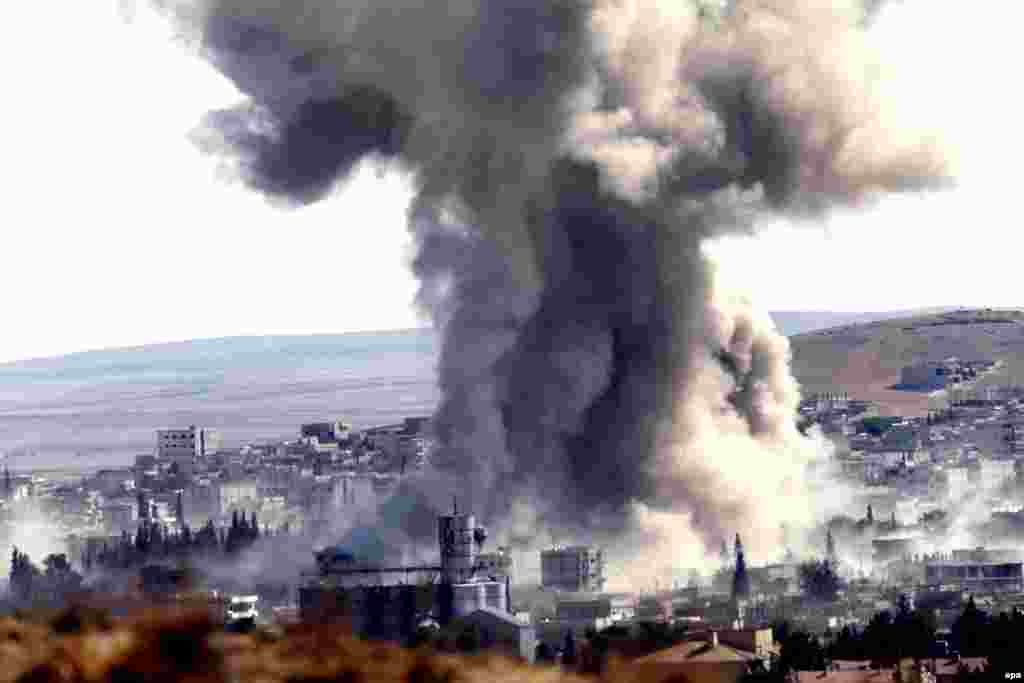 Smoke rises after an air strike by a suspected alliance war plane on Islamic State targets in the west of the Syrian town of Kobani. (epa/Sedat Suna)