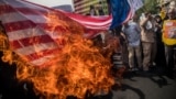 Supporters of the Islamic republic burn a U.S. flag during a protest against President Donald Trump's decision to walk out of a 2015 nuclear deal, in Tehran in May 2018.