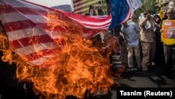 Supporters of the Islamic republic burn a U.S. flag during a protest against President Donald Trump's decision to walk out of a 2015 nuclear deal, in Tehran in May 2018.