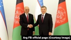 Президент Узбекистана Шавкат Мирзияев (справа) обменивается рукопожатием с прибывшим на конференцию в Ташкент президентом Афганистана Ашрафом Гани. 27 марта 2018 года.