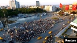 People stand facing Ataturk Cultural Center during a protest at Taksim Square in Istanbul in mid-June.