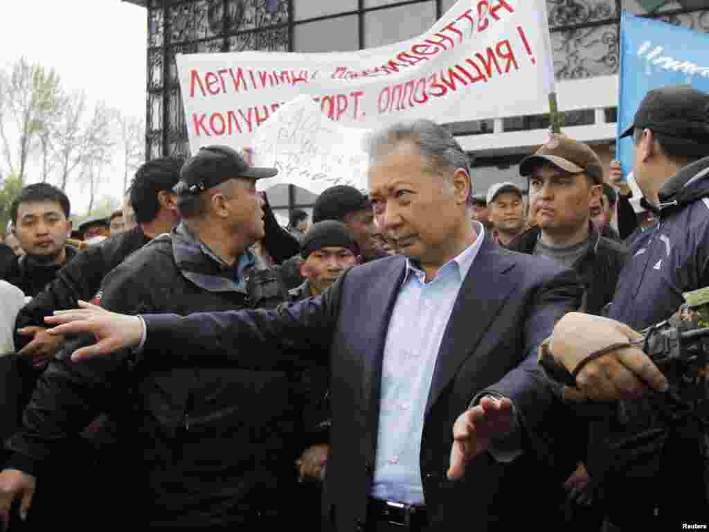 Телохранители помогают Бакиеву покинуть митинг своих сторонников после нападения сторонников временного правительства, Ош, 15 апреля 2010