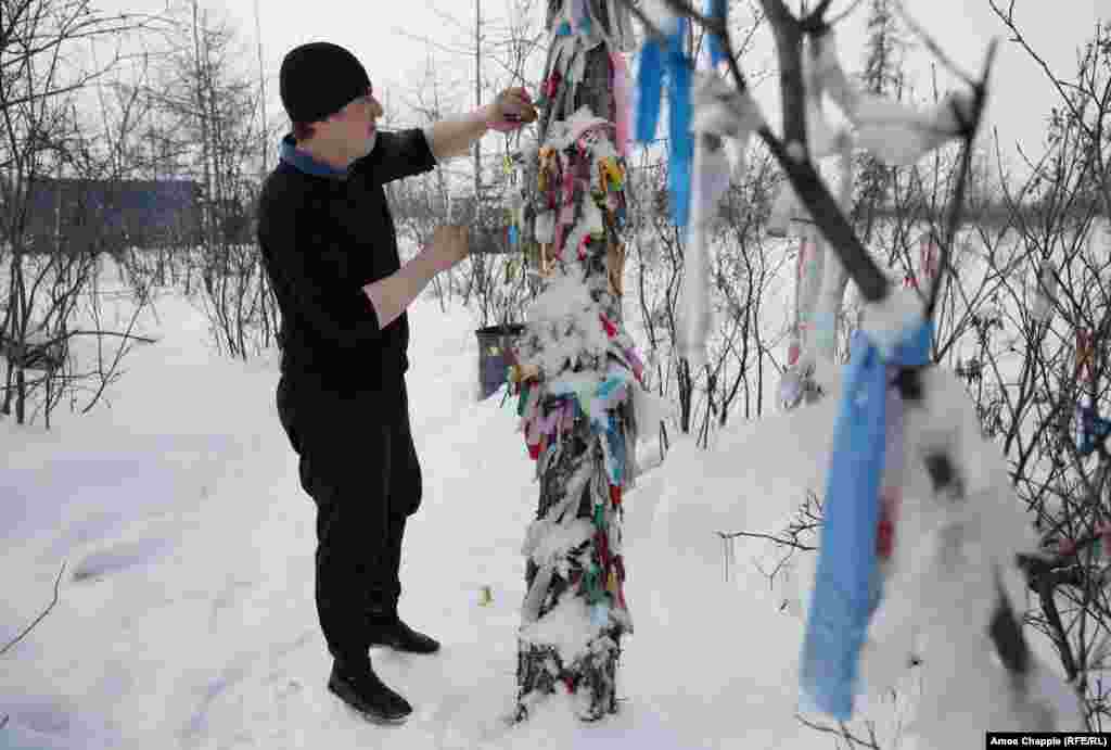 In the Yakutia region of Siberia, many ethnic Russians -- despite being Orthodox Christians -- show deep respect for the rituals of the shamanic world. This truck driver is leaving a gift of cigarettes at a sacred site, a ritual he carries out each time he makes the treacherous journey along the frozen Indigirka River. 