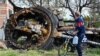 UKRAINE – A local resident looks at a destroyed Russian tank next to a residential house in the village of Mala Rogan, east of Kharkiv, on May 15, 2022