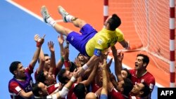 بازیکنان ایرانی در حالی که فالکائوی برزیلی را رو دست بلند کرده‌اند، جشن پیروزی گرفته‌اند