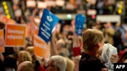 A mother holds her infant at a party campaign event in Berlin on September 21 for Chancellor Angela Merkel's Christian Democratic Union (CDU).