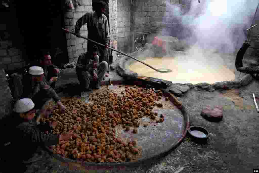 Pakistani men prepare brown sugar from sugarcane juice. (AFP/Bilawal Arbab)