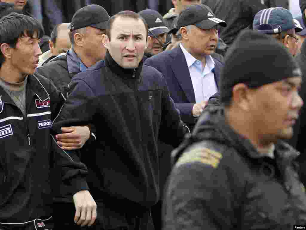 Телохранители помогают Бакиеву покинуть митинг своих сторонников после нападения сторонников Временного правительства. Ош, 15 апреля 2010 года. 