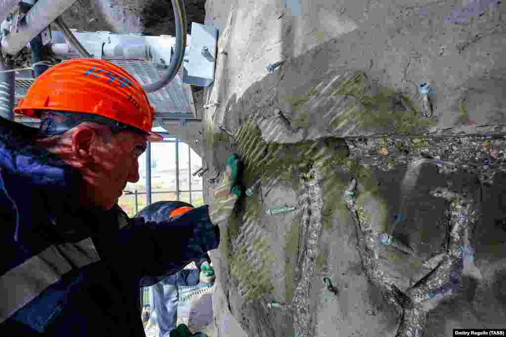 The workers are tasked with filling in cracks in the concrete and coating the statue in a weather-resistant lacquer.