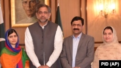 Pakistani Nobel Peace Prize winner Malala Yousafzai (L) and her parents pose for a photograph with Pakistani Prime Minister Shahid Khaqan Abbasi in Islamabad on March 29, 2018