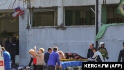 EDITORS NOTE: Graphic content / Rescuers carry an injured victim of a blast at at a college in the city of Kerch on October 17, 2018. - Thirteen people were killed and 50 more wounded, most of them teenagers, after a blast tore into a college canteen in R