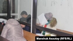 The defendants in the murder case of figure skater Denis Ten confer at the preliminary hearing in Almaty on December 25.