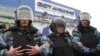 Riot police guard the Ostankino television tower in Moscow during a protest over the NTV program that alleged anti-Putin protesters were paid to attend demonstrations.